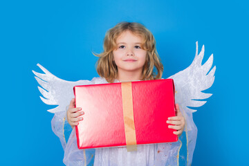 Kid boy angel with gift box present. Valentine's day. Blonde cute child with angel wings on a blue...