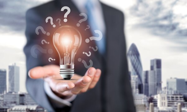 Businessman hand holding glowing lamp lightbulb with question mark
