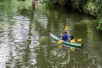 Married couple a man and a woman prefer an active lifestyle and exercise their muscles by paddling...