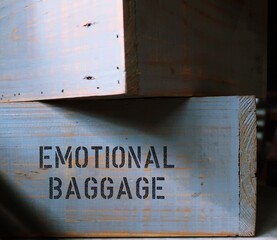 Wood boxes with text written EMOTIONAL BAGGAGE  - concept of carrying all disappointments, wrongs and trauma of the past in a heavy load, negative, unprocessed emotions from past experiences - obrazy, fototapety, plakaty
