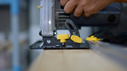 Fototapeta premium the master works with a manual circular saw on wood, close-up