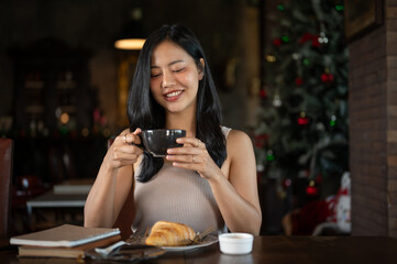 Young rich Asian woman having a hot coffee with breakfast in her elegant home.