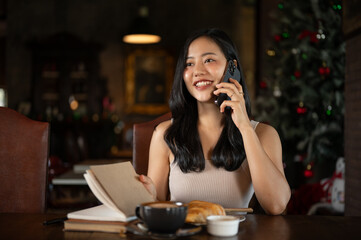 Young rich Asian woman working from home, calling her employee in her luxury vintage home office.