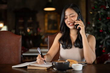 Young rich Asian woman working from home, calling her employee in her luxury vintage home office.