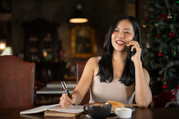 Young rich Asian woman working from home, calling her employee in her luxury vintage home office.