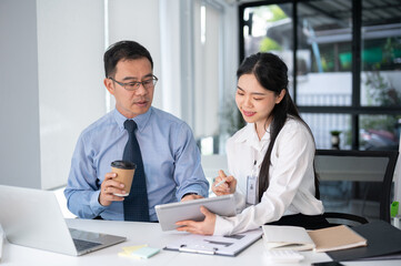 Young beautiful businesswoman asking for an advise from senior supervisor in the office room.