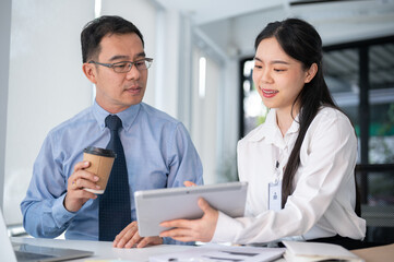 Fototapeta premium Young beautiful businesswoman asking for an advise from senior supervisor in the office room.