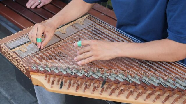 hands of musician playing on cimbalom or dulcimer, 