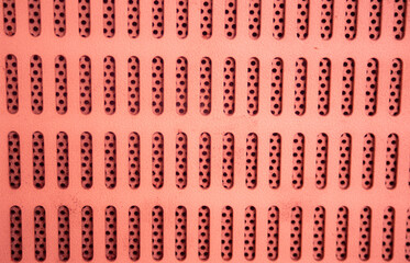 abstract background of a perforated metal plate with holes.