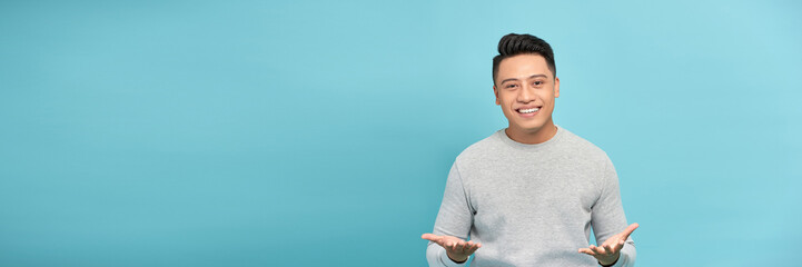 Friendly businessman with welcoming gesture isolated on blue background