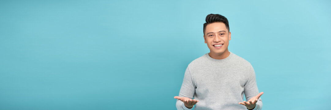 Friendly businessman with welcoming gesture isolated on blue background