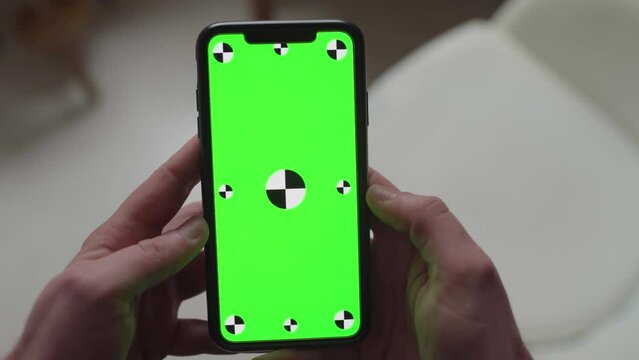 performing touch gestures using fingers on smartphone with green screen display with tracking markers, portrait orientation