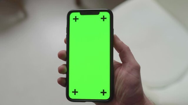 swinging a smartphone in front of the camera with green screen display and tracking markers, static