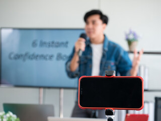Asian speaker man teach about 6 instant confidence booster online private course for self esteem improvement while record video and share TV live screen in education studio room