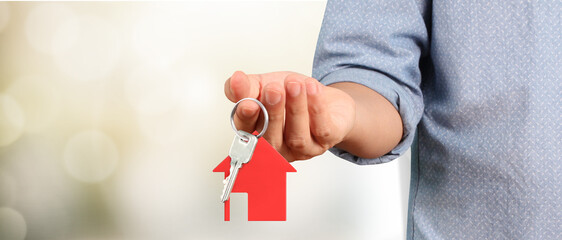 Real estate agent handing over  house keys in hand