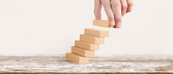 Hand liken business person stepping up  toy staircase