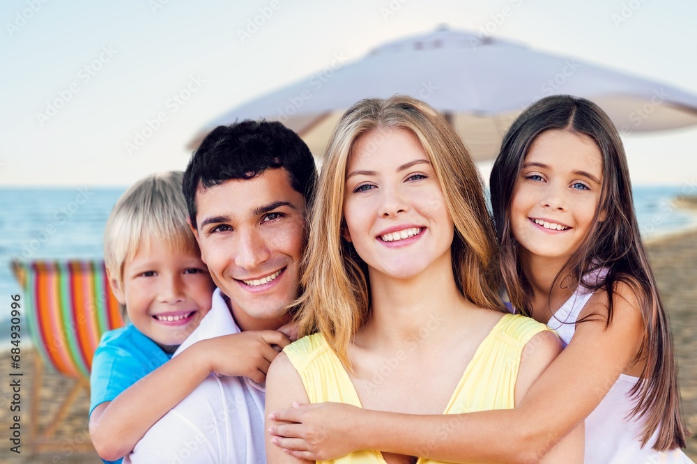 Wall mural Happy family. young parents and children walk on the beach.