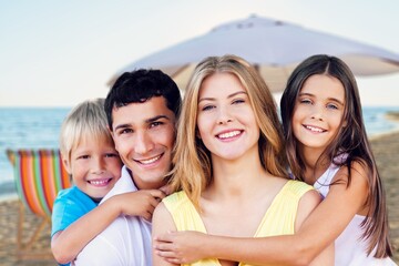 Happy family. young parents and children walk on the beach.