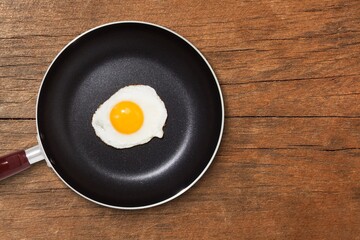 Tasty fried egg on pan on the desk