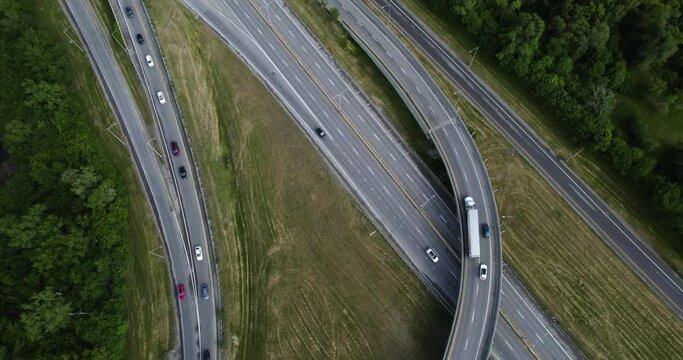 Aerial view following a semi-truck driving on a highway, cloudy day in Canada