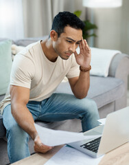 Man, bills and headache on laptop and sofa for finance mistake, debt review or taxes stress at...