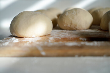 close ups of homemade pizza and pretzel dough on a cutting board with flour 