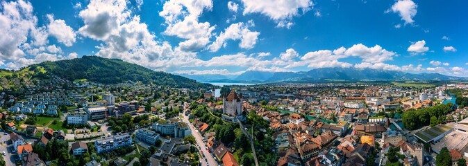 Panorama of Thun city with Alps and Thunersee lake, Switzerland. Historical Thun city and lake Thun with Bernese Highlands swiss Alps mountains in background, Canton Bern, Switzerland. - obrazy, fototapety, plakaty