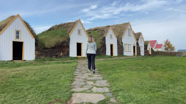 Blonde woman visiting the Historic Glaumb&aelig;r Turf Houses in north Iceland