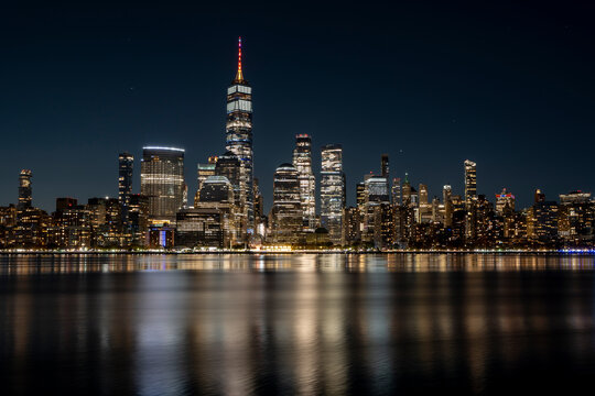 Manhattan Skyline at night with beautiful reflection in the hudson river in the front