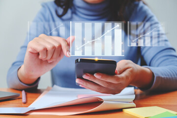 Businesswoman analyzing growing chart floating above digital tablet computer screen, showing successful increase in business profit