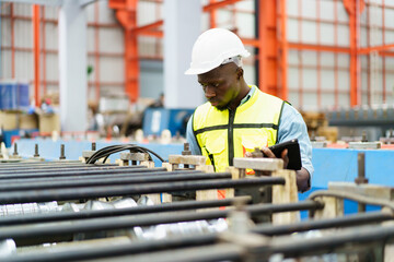 American - African worker inspecting machine in factory, machanical engineer working on machines in...