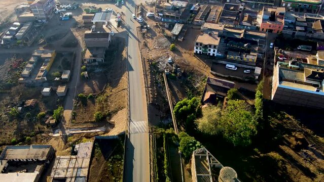 Sunrise- Kenya landscape with a village, Kilimanjaro and Amboseli national park - tracking, drone aerial view. skyline of Loitokitok in background during sunny day. Two class society in Africa.