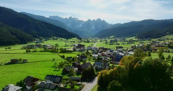 Beautiful aerial view of Gosau municipality in Austria. Small villages and asphalt road visible in a saturated green fields between mountains. High quality 4k prores footage.