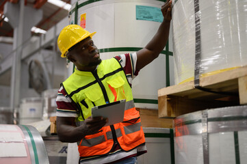 Engineer inspects and inspects shop at steel role material warehouse Smart industrial workers...