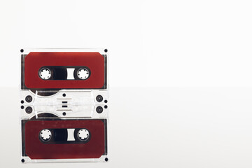 Close up of red cassette tape on white background with reflection