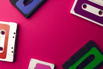 Overhead view of colourful cassette tapes with copy space on pink background