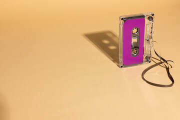 Close up of purple cassette tape with copy space on beige background
