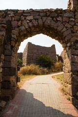 A beautiful path between the Ruins of the Wall of an ancient fort architecture, India. Ancient rocks gate