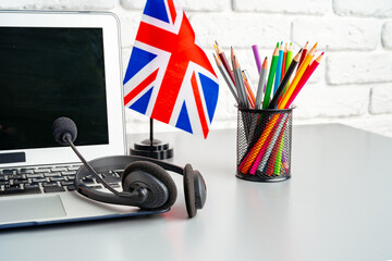 Laptop and flag of UK on desk. English language learning concept - obrazy, fototapety, plakaty