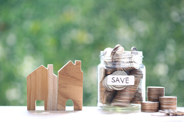 Finance, Model house and coins money in glass bottle on nature green background,Business investment...