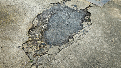 A picture of potholes at damage road, Damaged asphalt pavement road with potholes. Potholes on a...