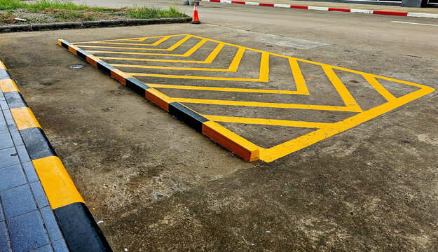 Yellow diagonal stripes between parallel lines painted on a paved road. Yellow diagonal stripes on road. Traffic Signal Objects diagonal yellow stripes painted on streets.