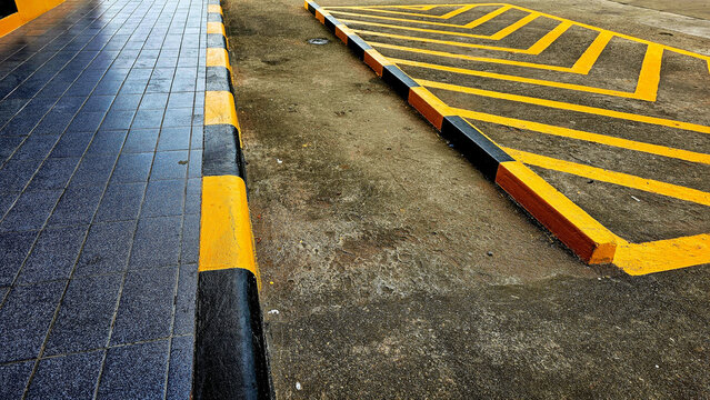 Yellow diagonal stripes between parallel lines painted on a paved road. Yellow diagonal stripes on road. Traffic Signal Objects diagonal yellow stripes painted on streets.