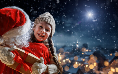 child girl and Santa Claus with gift