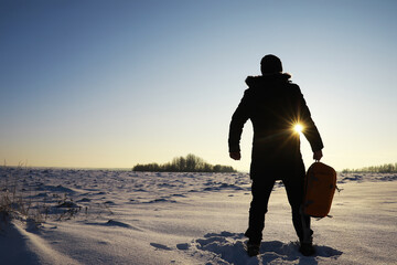 Hiking winter landscape. A man with a backpack travels in winter. A man in a snowy field. - obrazy, fototapety, plakaty