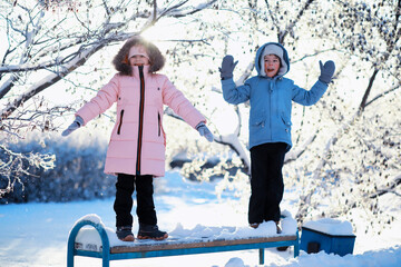 Family with children play snowy winter games in the park. Winter holidays and family vacation....