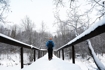 A man with a backpack travels in winter. A man in a snowy field. Hiking winter landscape.
