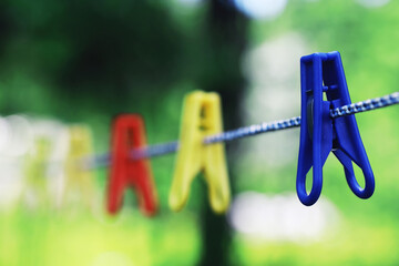 Dry clothes outside. Clothes on a rope. Clothespins on a clothesline in summer.