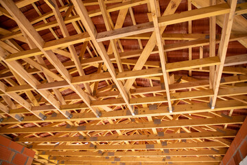 wooden house frame supporting the roof tiles of new home under construction