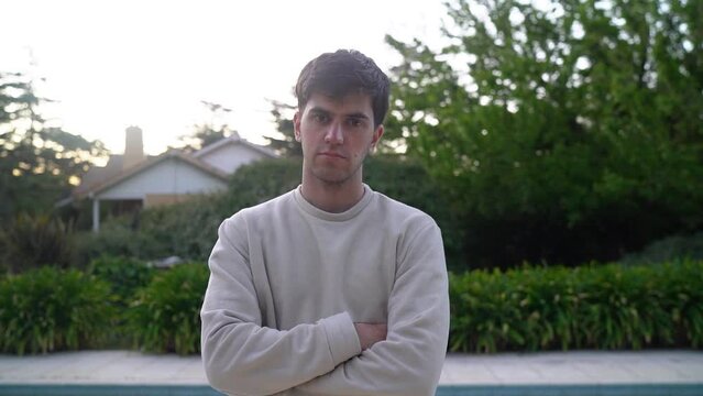 Young Man Standing Near Poolside Outdoor Looking At The Camera. Medium Close-up 